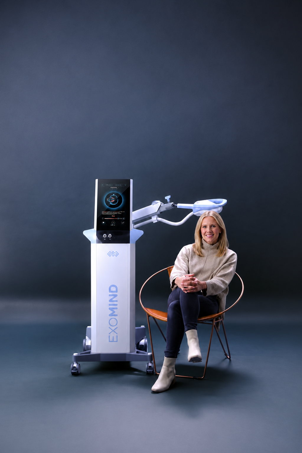 Exomind TMS therapy device with patient seated beside it